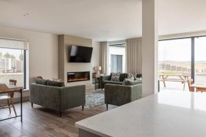 a living room with couches and a fireplace at Leenan at Ballyliffin Beach Houses, Pollan Bay in Ballyliffin