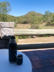 una bottiglia d'acqua appoggiata su un tavolo con una tazza di Campo la Sierra - El rincón alemán en San Luis a Volcán