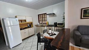 kuchnia i salon ze stołem i lodówką w obiekcie Casa aconchegante Rio das Ostras w mieście Rio das Ostras