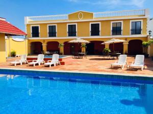 a resort with a pool and chairs and umbrellas at Hotel Bello Veracruz in Veracruz
