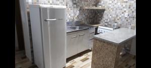 a white refrigerator in a kitchen with a sink at Linda kitnet estilo loft! unidade 2 in Guarapuava