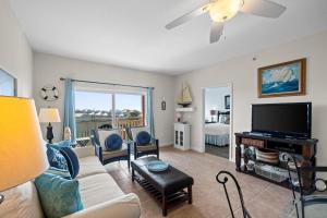 a living room with a couch and a flat screen tv at Waterside Village by Panhandle Getaways in Mexico Beach