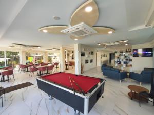 a pool table in a room with tables and chairs at Hotel Palazzi in Gabicce Mare