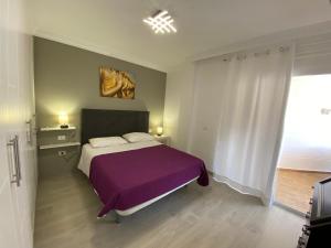 une chambre avec un grand lit avec une couverture violette dans l'établissement Ocean View The Sunset, à Adeje 25 autres photos