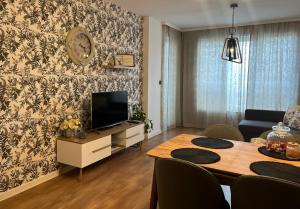 a living room with a dining table and a tv at Apartment Stella in Varna City