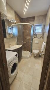 y baño con ducha y lavadora. en Apartman SeaShell, en Primošten 6 fotos más