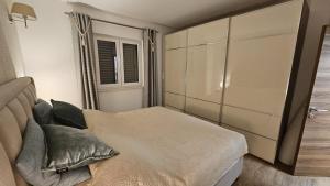 un dormitorio con una cama y una ventana en Apartman SeaShell, en Primošten