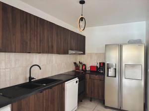 a kitchen with a stainless steel refrigerator and wooden cabinets at Ti Kaz in Saint-François