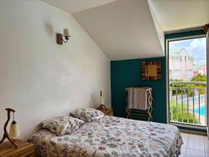 a bedroom with a bed and a large window at Ti Kaz in Saint-François +52 photos