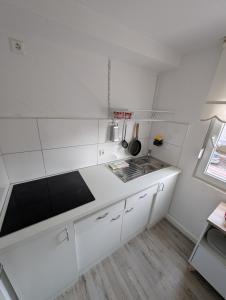 a white kitchen with a sink and a counter at 2 Room apartment in Göppingen