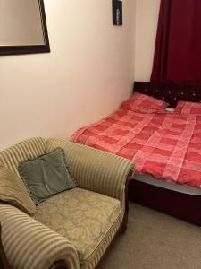 1 dormitorio con 1 cama y 1 sofá con almohada en Hanham Lodge, en Longwell Green