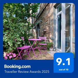 una mesa púrpura y sillas sentadas en un jardín en Garden Flat, en Edimburgo