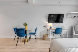 a room with blue chairs and a table and a tv at Initial / Simplicity / Québec in Quebec City