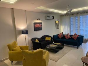 a living room with a blue couch and chairs at High-Rise Presidential Suites In Downtown Islamabad in Islamabad