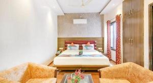 a bedroom with a bed and two chairs at King Heritage in Lucknow