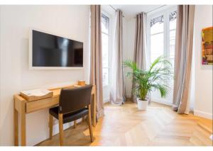 a room with a desk and a television on a wall at Appartement de luxe Place Bellecour in Lyon