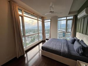 a bedroom with large windows and a bed with a view at High-Rise Presidential Suites In Downtown Islamabad in Islamabad