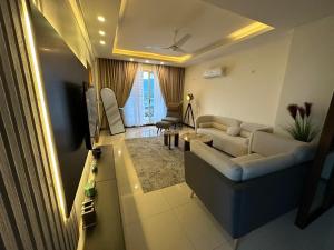 a living room with a couch and a tv at High-Rise Presidential Suites In Downtown Islamabad in Islamabad