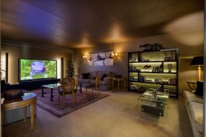 a living room with a couch and a tv at Hotel Cascais Miragem Health & Spa in Cascais