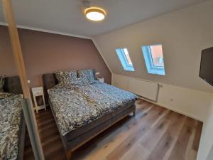 a bedroom with a bed and two windows at Ferienhaus Urlaub-in-Edenkoben in Edenkoben