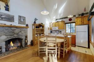 a kitchen with a table and a stone fireplace at Circle 4 Ranch 31 | Discover Sunriver in Sunriver