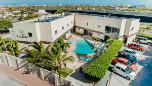 an aerial view of a building with a pool and parked cars at Hotel RH Boutique Aruba in Oranjestad
