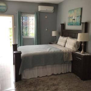 una camera da letto con un letto, due lampade e una finestra di Hills Royale Villa -Ironshore Montego Bay a Montego Bay