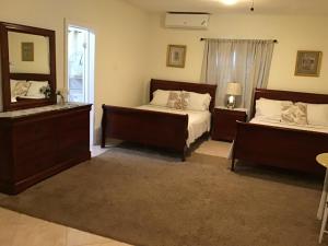 una camera con due letti, uno specchio e una finestra di Hills Royale Villa -Ironshore Montego Bay a Montego Bay Altre 57 foto