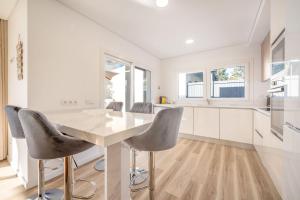 a white kitchen with a table and chairs at GuestReady - Striking Hideaway in Almada in Charneca