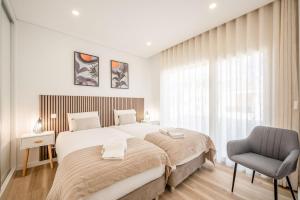 a bedroom with a large bed and a chair at GuestReady - Striking Hideaway in Almada in Charneca