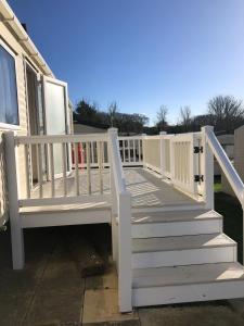a white deck with a white railing on a house at Family friendly, 3-bedroom holiday home in Bembridge