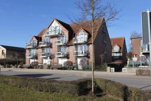 a large brick building with a tree in front of it at Strandduene Stranddüne Appartement 3 in Haffkrug