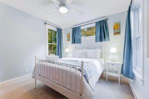 a bedroom with a white bed with blue curtains at 5 Farm View in Cherry Valley