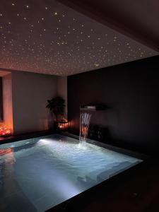 a swimming pool with a water fountain in a room at Il Grottino Relais & Spa in Gualdo Cattaneo