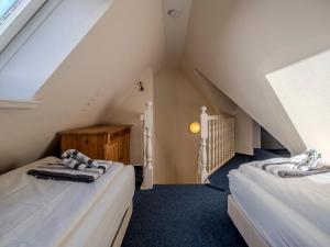 a attic room with two beds and a window at Landhaus St Niels in Westerland (Sylt)