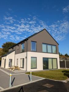 a large house with a lot of windows at Binion at Ballyliffin Beach Houses, Pollan Bay in Ballyliffin