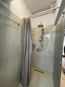 a bathroom with a shower with a glass door at Destinacion Central Room in Tirana