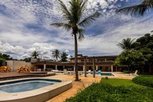 a house with a palm tree and a swimming pool at Pousada Porto do Rio in Caraguatatuba +19 photos