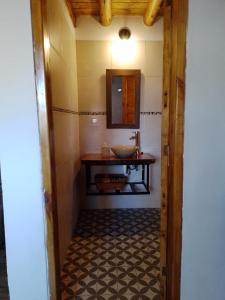 a bathroom with a sink and a mirror at Alojamiento Küme Kiyen in Aluminé