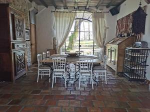 a dining room with a table and chairs and a window at Maison Basta in Orthevielle