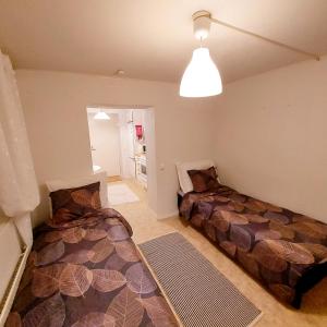 1 dormitorio con 2 camas y luz en Huoneisto Pikku Neristan, en Kokkola