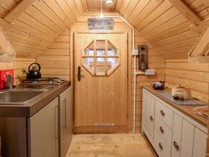 a kitchen with a wooden door in a cabin at Enchanted Cottage in Snettisham