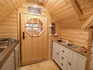 a kitchen with a wooden door in a cabin at Enchanted Cottage in Snettisham