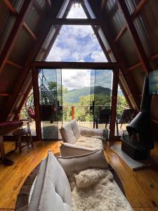 a living room with a large window in a cabin at Cabana Fé in Nonoai