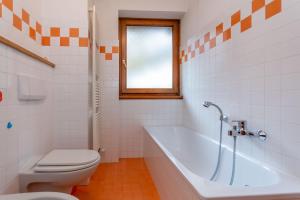 a bathroom with a tub and a toilet and a sink at Villa Eden in Falcade +19 photos
