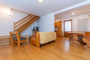 a living room with a staircase and a table and chairs at Villa Eden in Falcade