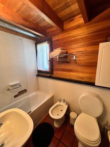 Un baño con un inodoro blanco y un lavabo. en Inmejorable ubicación, en San Martín de los Andes