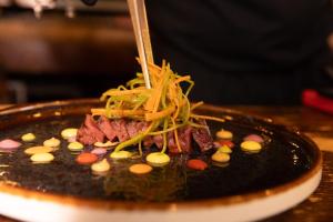 a plate of food with meat and vegetables on it at Il Grottino Relais & Spa in Gualdo Cattaneo