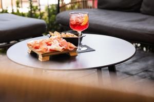 a table with a plate of food and a glass of wine at Il Grottino Relais & Spa in Gualdo Cattaneo