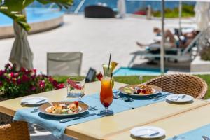 a table with two plates of food and a drink at Hotel Cascais Miragem Health & Spa in Cascais